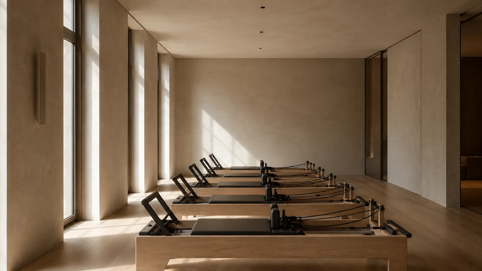 The reformer room: a row of reformers in a calm, warm-lit studio.